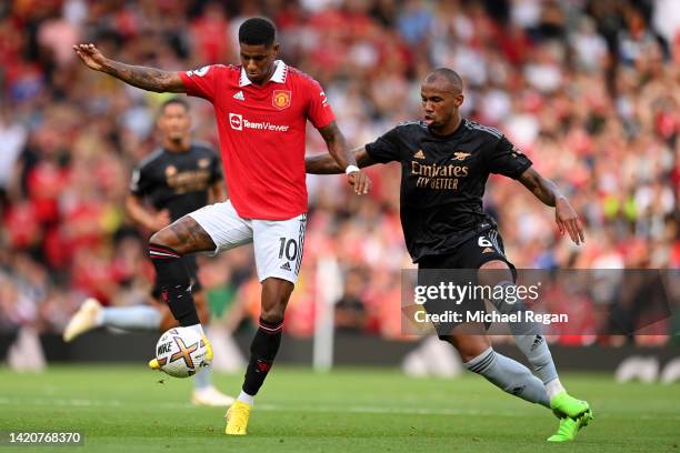 Marcus Rashford of Manchester United is challenged by Gabriel Magalhaes of Arsenal during the Premier League match between Manchester United and...