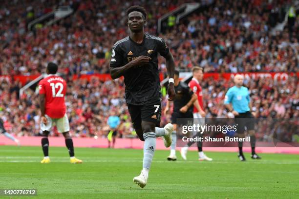 Bukayo Saka of Arsenal celebrates after scoring their sides first goal during the Premier League match between Manchester United and Arsenal FC at...