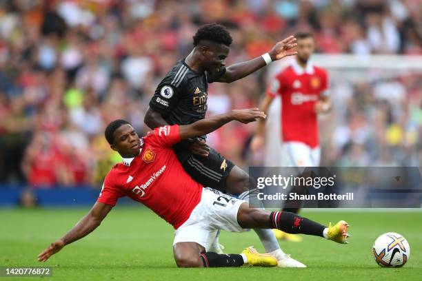 Tyrell Malacia of Manchester United challenges Bukayo Saka of Arsenal during the Premier League match between Manchester United and Arsenal FC at Old...