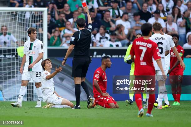 Ko Itakura of Borussia Monchengladbach is shown a red card by referee Deniz Aytekin during the Bundesliga match between Borussia Moenchengladbach and...