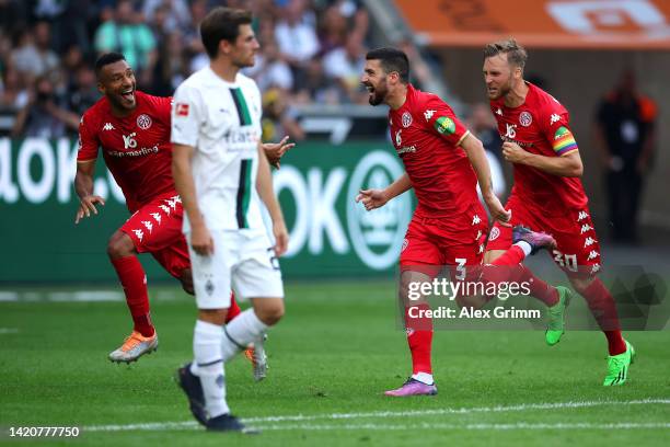 Aaron Caricol of FSV Mainz celebrates with teammates after scoring their team's first goal from a free kick during the Bundesliga match between...