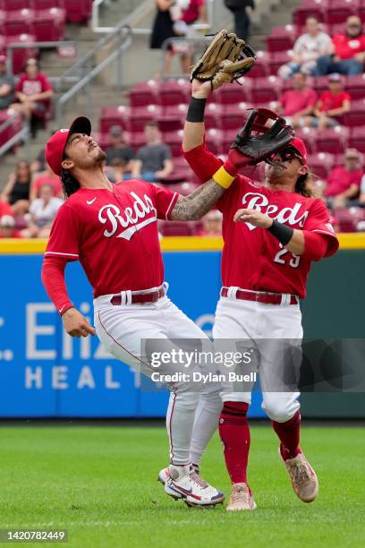 Jonathan India and TJ Friedl of the Cincinnati Reds collide as Friedl makes the catch in the second inning against the Colorado Rockies during game...