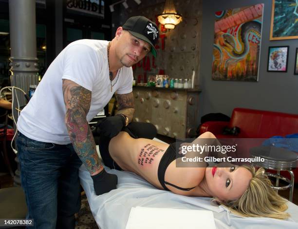 Lead singer Camilla Romestrand of the UK rock band Eddie The Gun gets tattooed by tattoo artist Ami James to promote the release of the new digital...