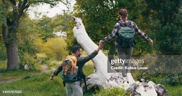 love, hiking or adventure with a young couple walking and exercising during a hike in the forest or woods. nature, trees and relationship with a healthy man and woman together outdoors for recreation - snap imagens e fotografias de stock