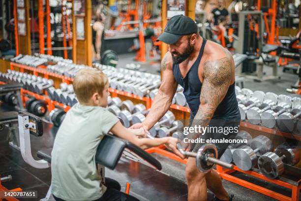 boy doing exercises in the gym with a man trainer athletic physique - young kid and barbell stock pictures, royalty-free photos & images