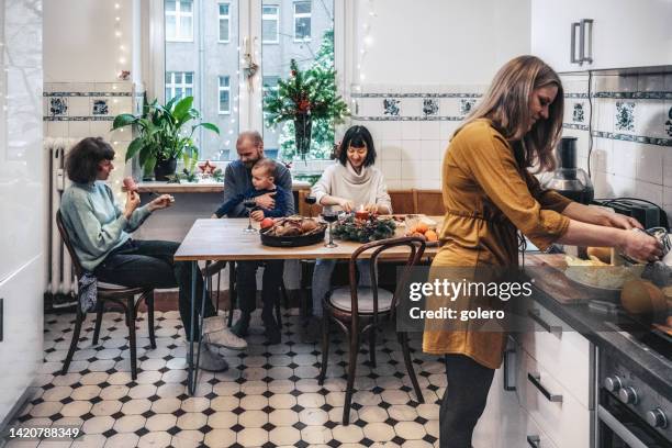 frau, die mahlzeiten in der küche für familie und freunde zubereitet - christmas cooking stock-fotos und bilder