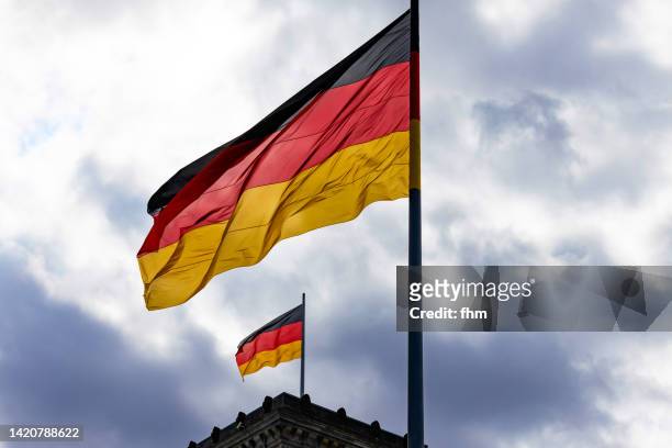 german flags on the reichstag building (german parliament) in berlin (germany) - central council stock pictures, royalty-free photos & images