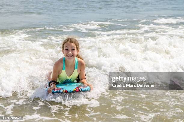teenage girl surfing into atlantic ocean - condado de cape may imagens e fotografias de stock