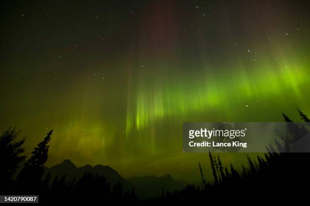The Northern Lights appear in the sky through a layer of smoke caused by multiple wildfires in the early hours of September 4, 2022 in Banff National...