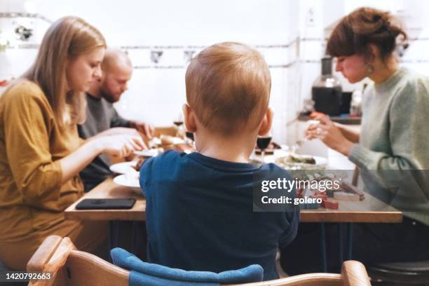 young family dining together with friends at table - patchwork stockfoto's en -beelden