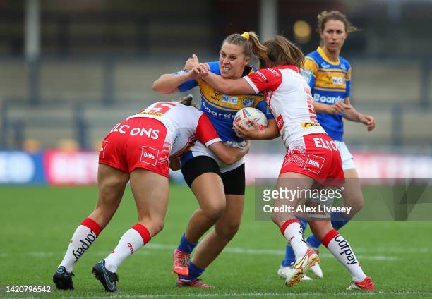 Chloe Kerrigan of Leeds Rhinos is tackled by Tara Jones and Bethany Stott of St Helens during the Betfred Women's Super League Semi Final match...