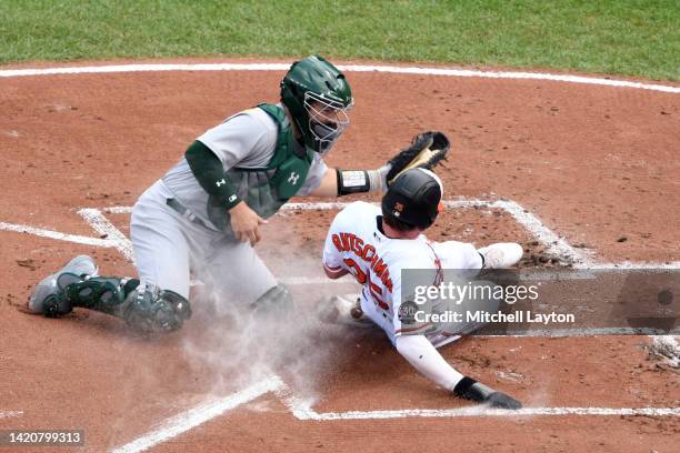 Shea Langeliers of the Oakland Athletics tags out Adley Rutschman of the Baltimore Orioles on a fielder's choice off the bat of Ryan Mountcastle in...