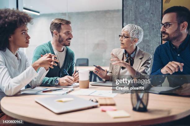 senior business woman working with her team - business talk stock pictures, royalty-free photos & images