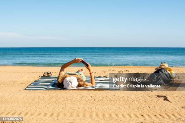 telecommuting on vacation, beach - cantabrian sea coast stock pictures, royalty-free photos & images