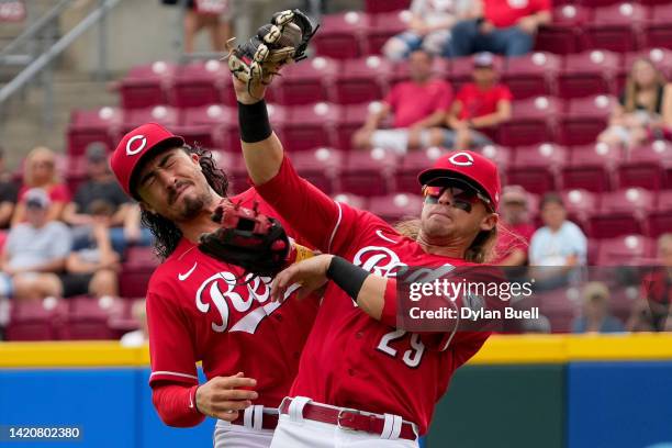 Jonathan India and TJ Friedl of the Cincinnati Reds collide on a catch by Friedl in the second inning against the Colorado Rockies during game one of...