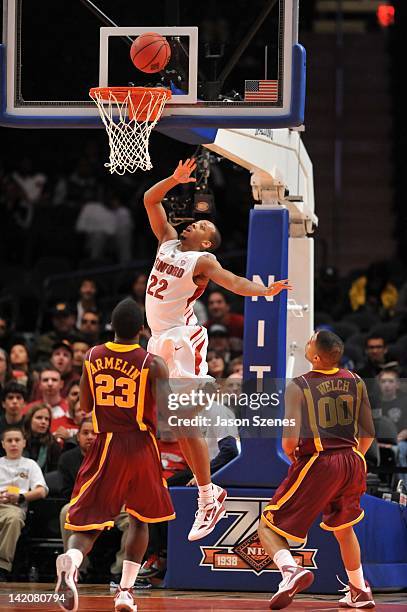 Jarrett Mann of the Stanford Cardinal puts up a shot past Gerald "Chip" Armelin and teammate Julian Welch of the Minnesota Golden Golphers in the...