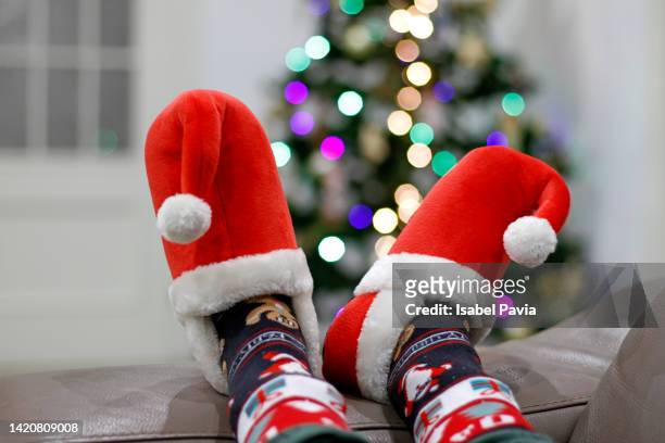 legs with xmas slippers on sofa - december 個照片及圖片檔