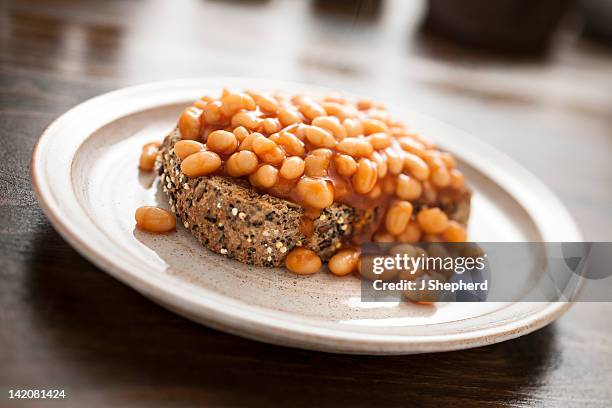 baked beans on mixed seed brown toast - baked beans stock pictures, royalty-free photos & images