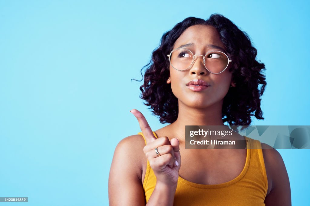 Verwirrte Frau, Denkrichtung und Studio-Mockup-Hintergrund. Nachdenkliche, verärgerte oder neugierige Person, die über eine Entscheidung nachdenkt. Mädchen mit Lösung oder Idee, die auf Marketingwerbung hinweist.