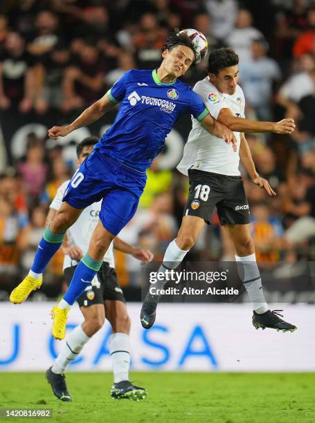 Enes Unal of Getafe CF jumps for the ball with Andre Almeida of Valencia CF during the LaLiga Santander match between Valencia CF and Getafe CF at...