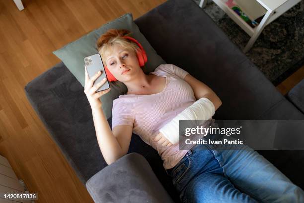 riposare a casa con un braccio ferito - broken arm foto e immagini stock