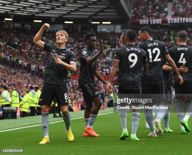 Martin Odegaard celebrates the Arsenal goal, scored by Bukayo Saka during the Premier League match between Manchester United and Arsenal FC at Old...