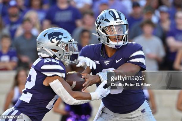 Quarterback Adrian Martinez of the Kansas State Wildcats hands the ball off to running back Deuce Vaughn during the first half against the South...