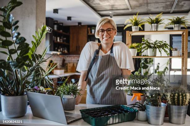 portrait of smiling botanist in her home garden - florest stock pictures, royalty-free photos & images