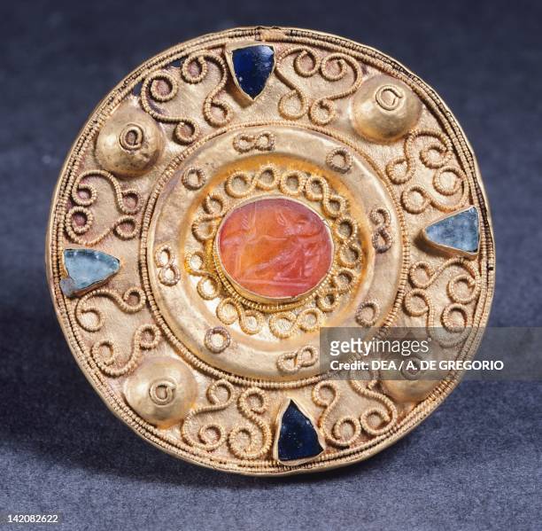 6th-7th century disc-shaped fibula set with antique gemstone from Castel Trosino, Italy. Goldsmith's art, Longobard civilization.