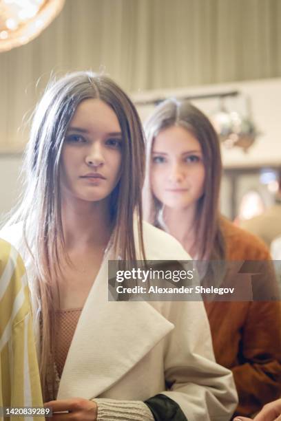 retrato feminino de uma mulher bonita que trabalha modelo de moda no desfile da semana de moda. fotos de bastidores, nos bastidores de uma nova coleção de roupas. garota usa óculos e chapéu. - desfile de moda - fotografias e filmes do acervo