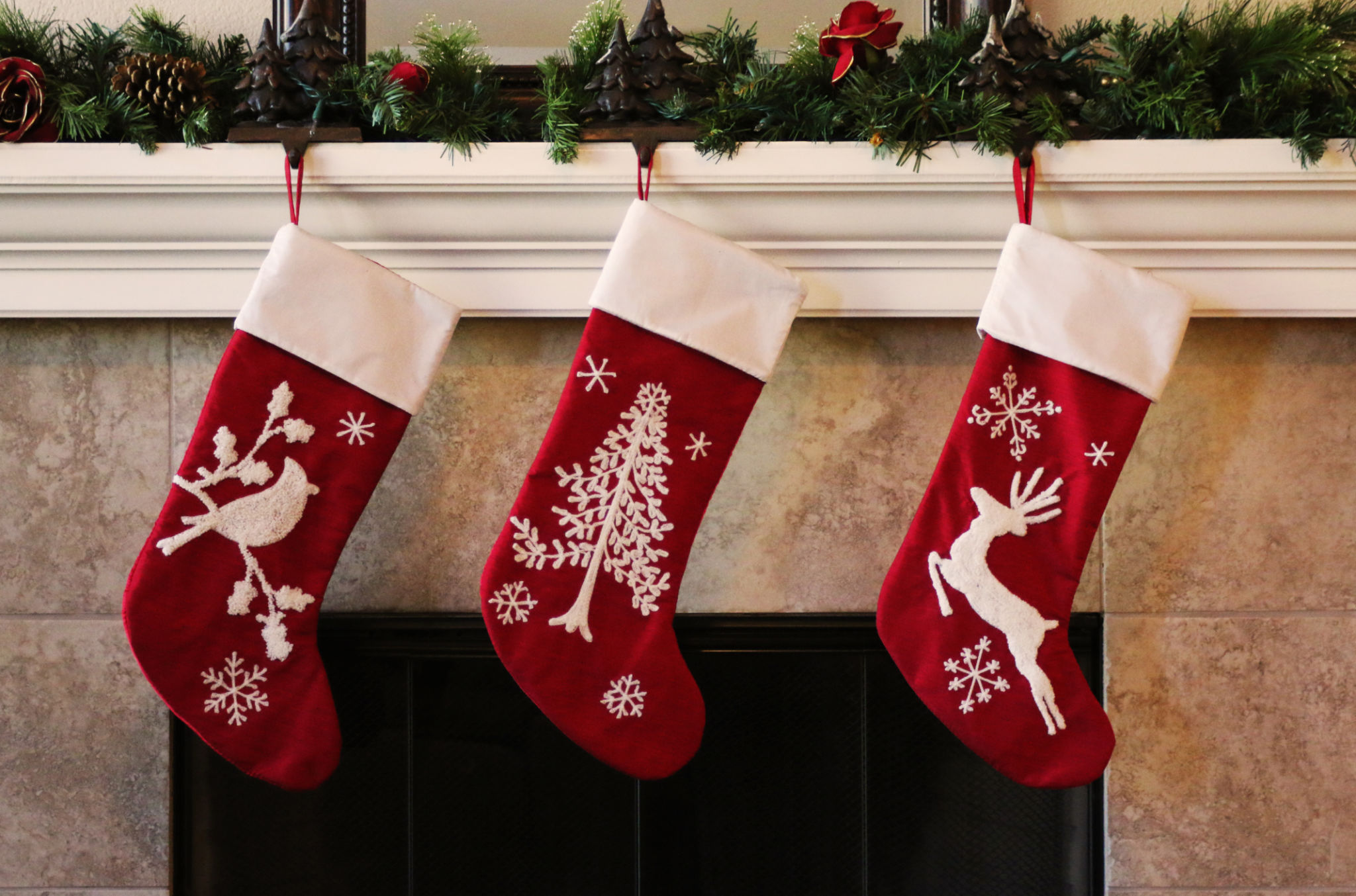 Three red christmas stockings on fireplace mantle Three red christmas stockings on fireplace mantle
