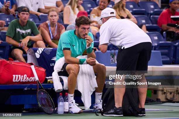 Pablo Carreno of Spain is looked at by a trainer against Karen Khachanov of Russia during their Men's Singles Fourth Round match on Day Seven of the...