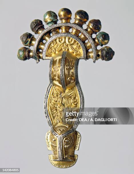 7th century bridge style gilt silver fibula with embossed decorations. Goldsmith's art, Longobard civilization.