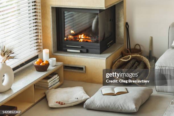 cozy nook in house with fireplace, pillows,  candles and opened book - reading nook stock pictures, royalty-free photos & images