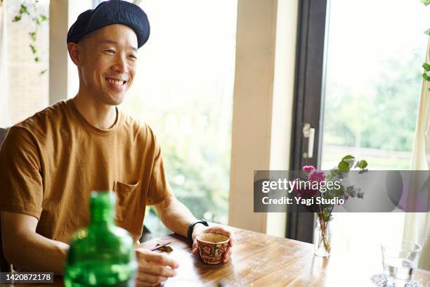 asian man enjoying lunch time at a vegan cafe. - plain t shirt stock pictures, royalty-free photos & images