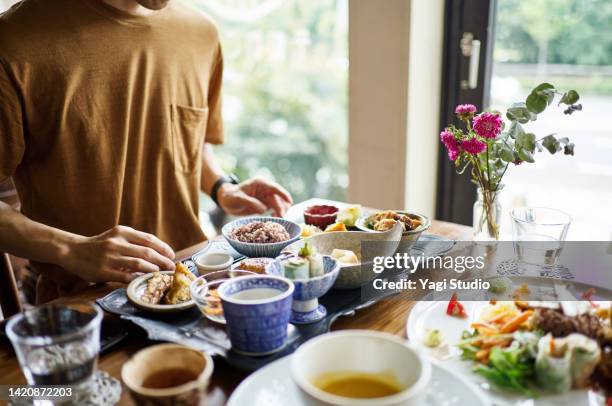 asian man eating a vegan menu at a vegan cafe. - japanese fat man bildbanksfoton och bilder