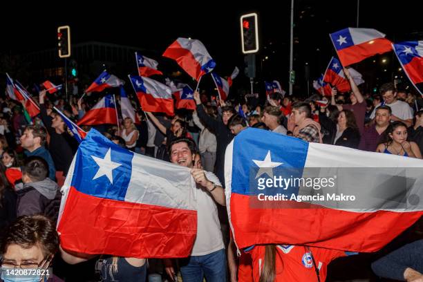 Demonstrators against a new constitution celebrate after the results of the referendum to approve or reject the current constitution imposed during...