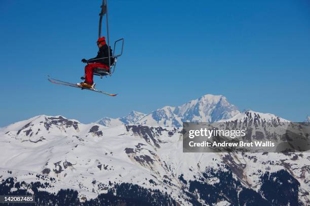 skier riding a mountain chairlift - ski lift stock pictures, royalty-free photos & images