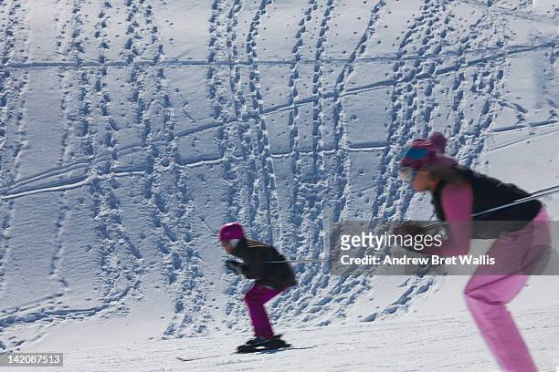 female skier and junior skier descend the piste - ski race ストックフォトと画像