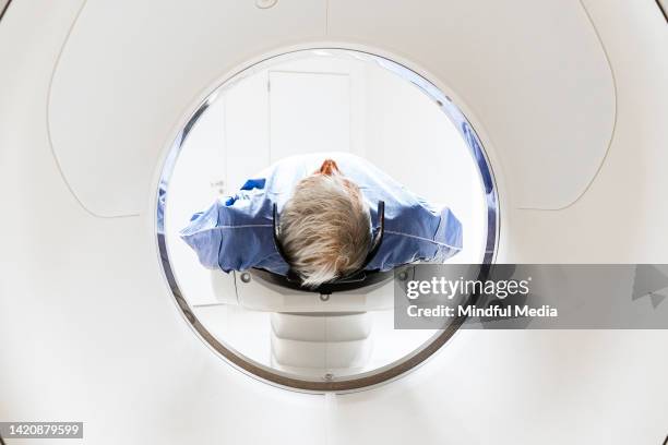 male patient going through mri scan machine tunnel - tomography stock pictures, royalty-free photos & images