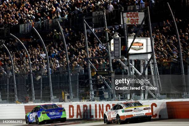 Erik Jones, driver of the FOCUSfactor Chevrolet, leads Denny Hamlin, driver of the Sport Clips Haircuts Toyota, to the finish line to win the NASCAR...