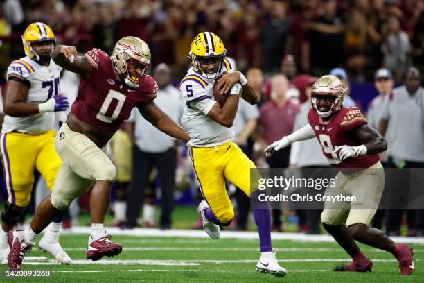 Quarterback Jayden Daniels of the LSU Tigers is tackled by defensive tackle Fabien Lovett of the Florida State Seminoles at Caesars Superdome on...