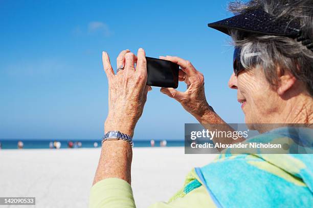 seniors using digital device - siesta key stockfoto's en -beelden