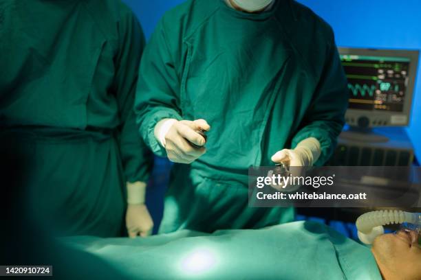 doctors using virtual reality glasses are surgery to patient at operating room. - performing arts event stockfoto's en -beelden