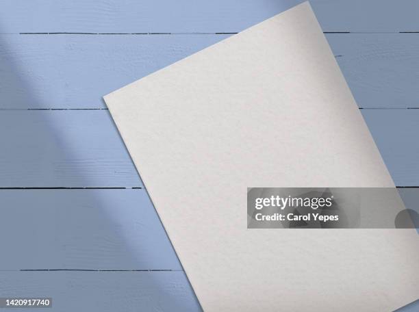 paper blank,template.in blue wooden surface casting shadows - notepad white table foto e immagini stock