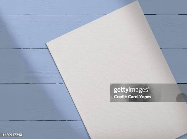 paper blank,template.in blue wooden surface casting shadows - counter surface level stock pictures, royalty-free photos & images