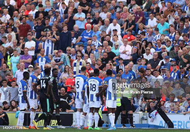 Match referee Tony Harrington checks the VAR screen during the Premier League match between Brighton & Hove Albion and Leicester City at American...