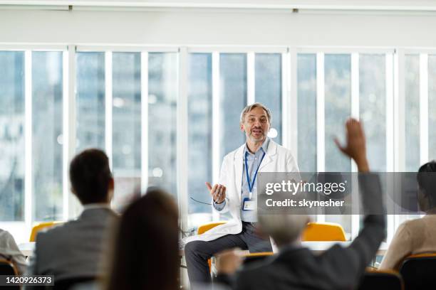 male medical expert leading a seminar in board room. - doctor presentation stock pictures, royalty-free photos & images