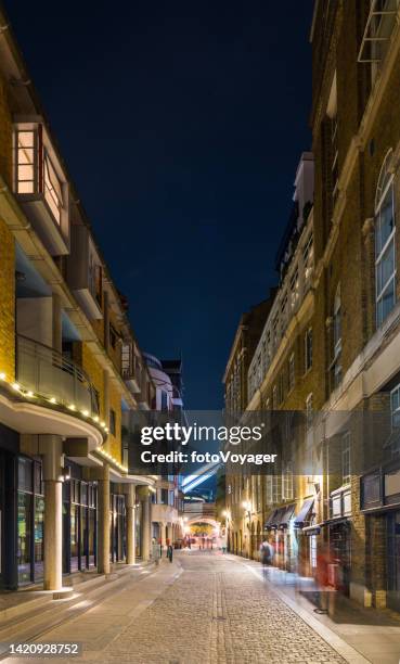 london cobbled street through warehouse apartments beside thames at night - vertical chelsea london stock pictures, royalty-free photos & images