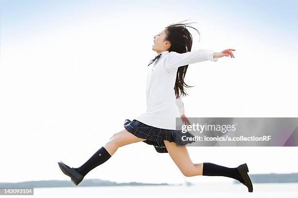 high school girl jumping - 女の子走る ストックフォトと画像